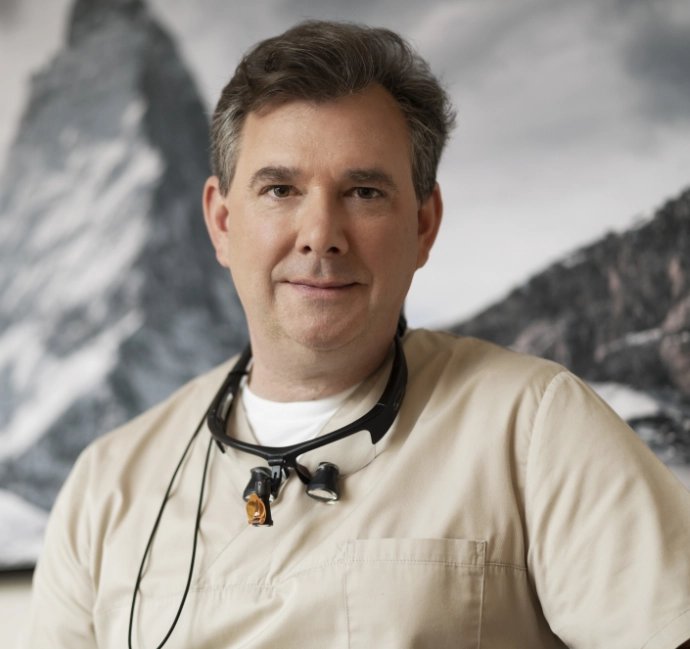 Portrait Dr. Max Heuermann vor Hintergrund mit Bergen